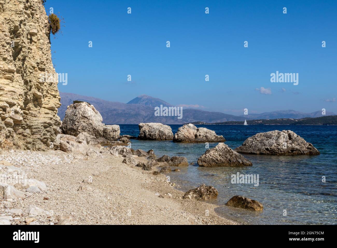 White pebbles and rocks cliffs beach with azure clear water and ...