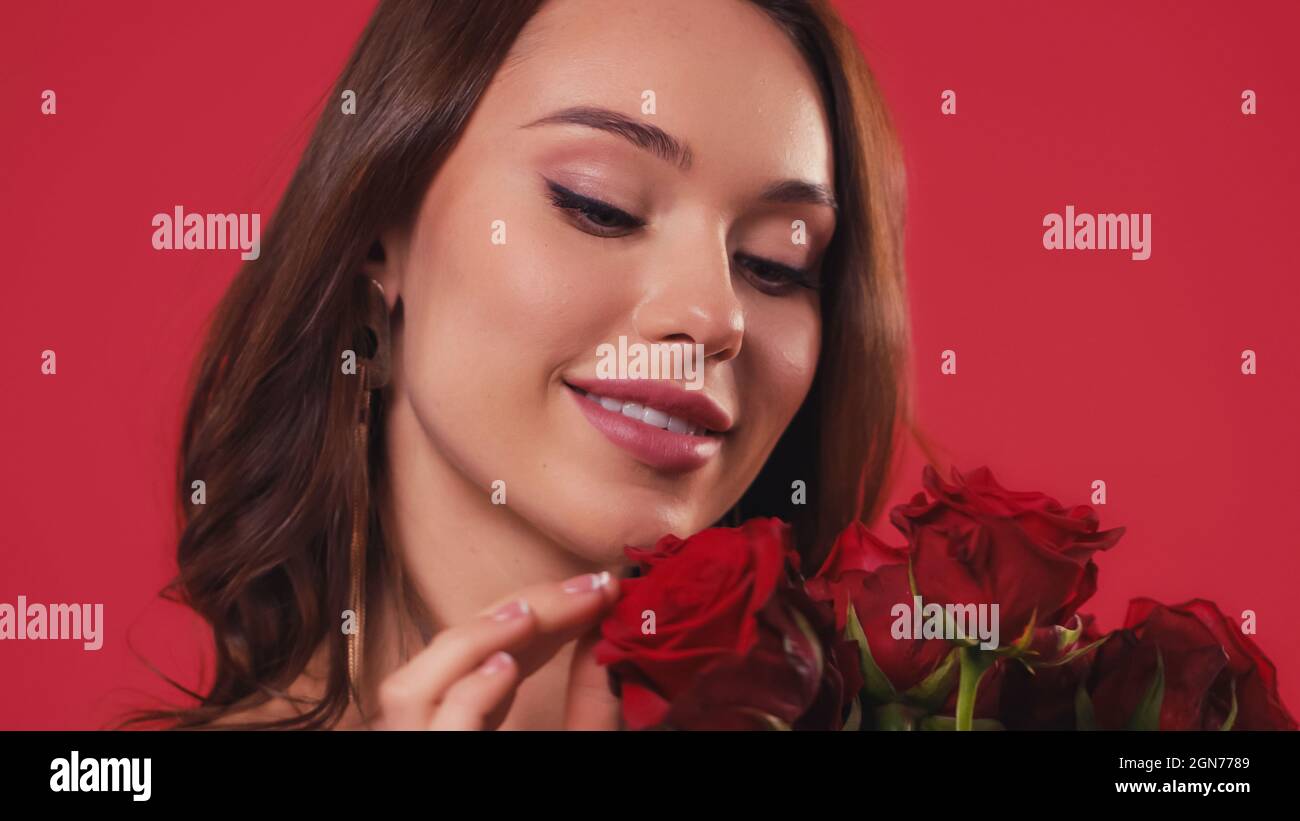 happy young woman touching roses isolated on red Stock Photo - Alamy