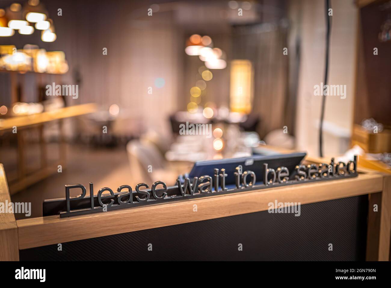 Wait to be seated metal sign in the restaurant Stock Photo Alamy