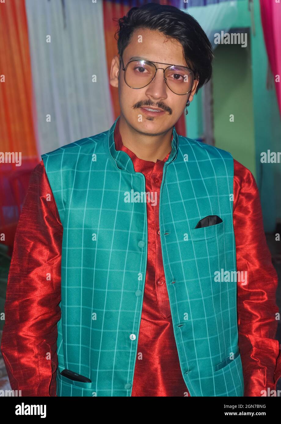 Portrait of a handsome Indian young guy with wearing kurta, pajama, nehru coat and sunglasses with looking at camera Stock Photo