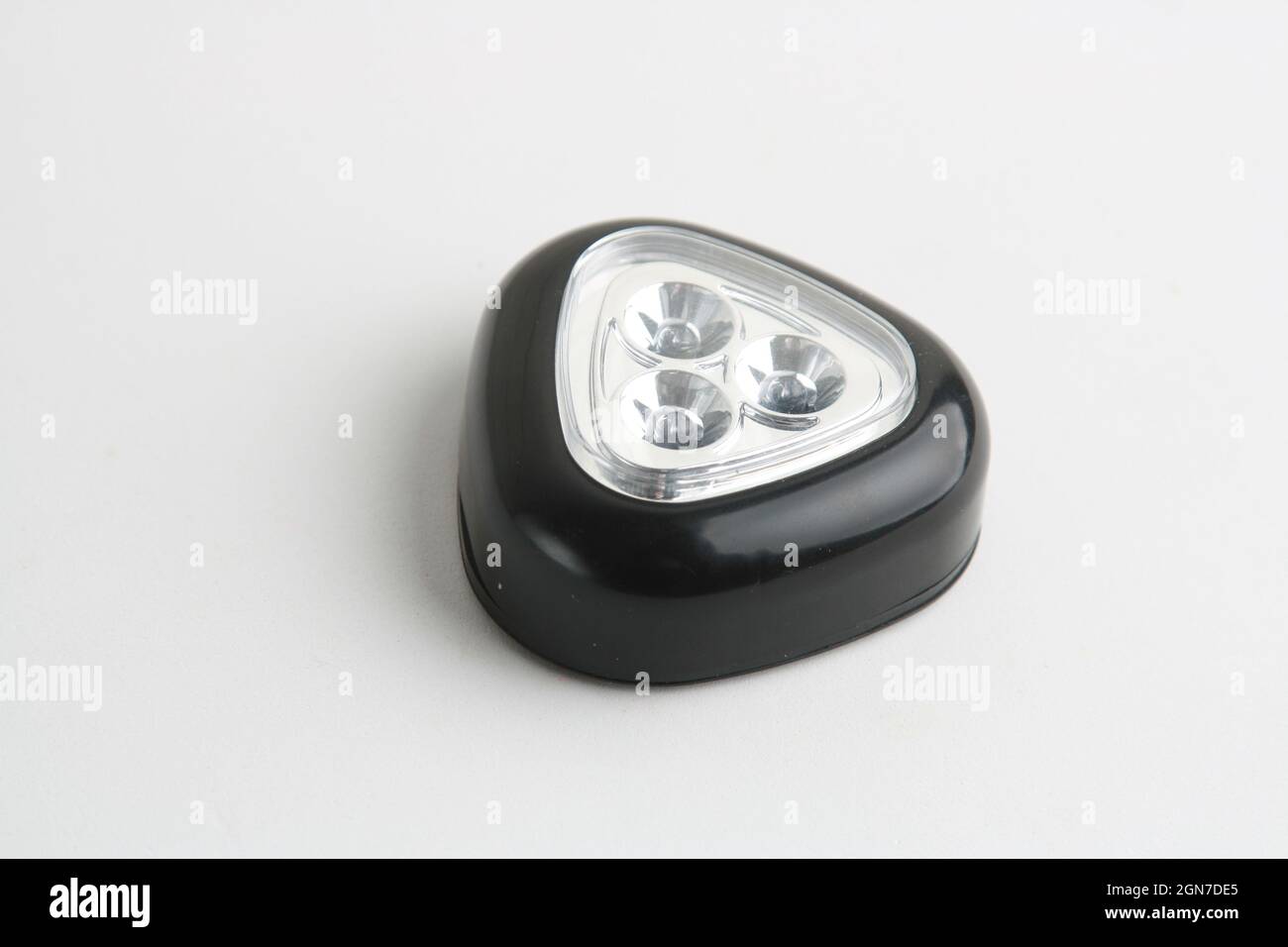 Triangular black flashlight on a white surface Stock Photo - Alamy