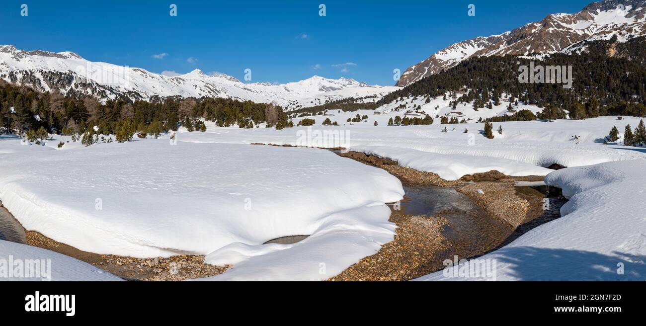 Panorama with lots of snow on Lukmanier in Ticino, on the Swiss Alps and a romantic stream through the landscape. Nobody inside Stock Photo