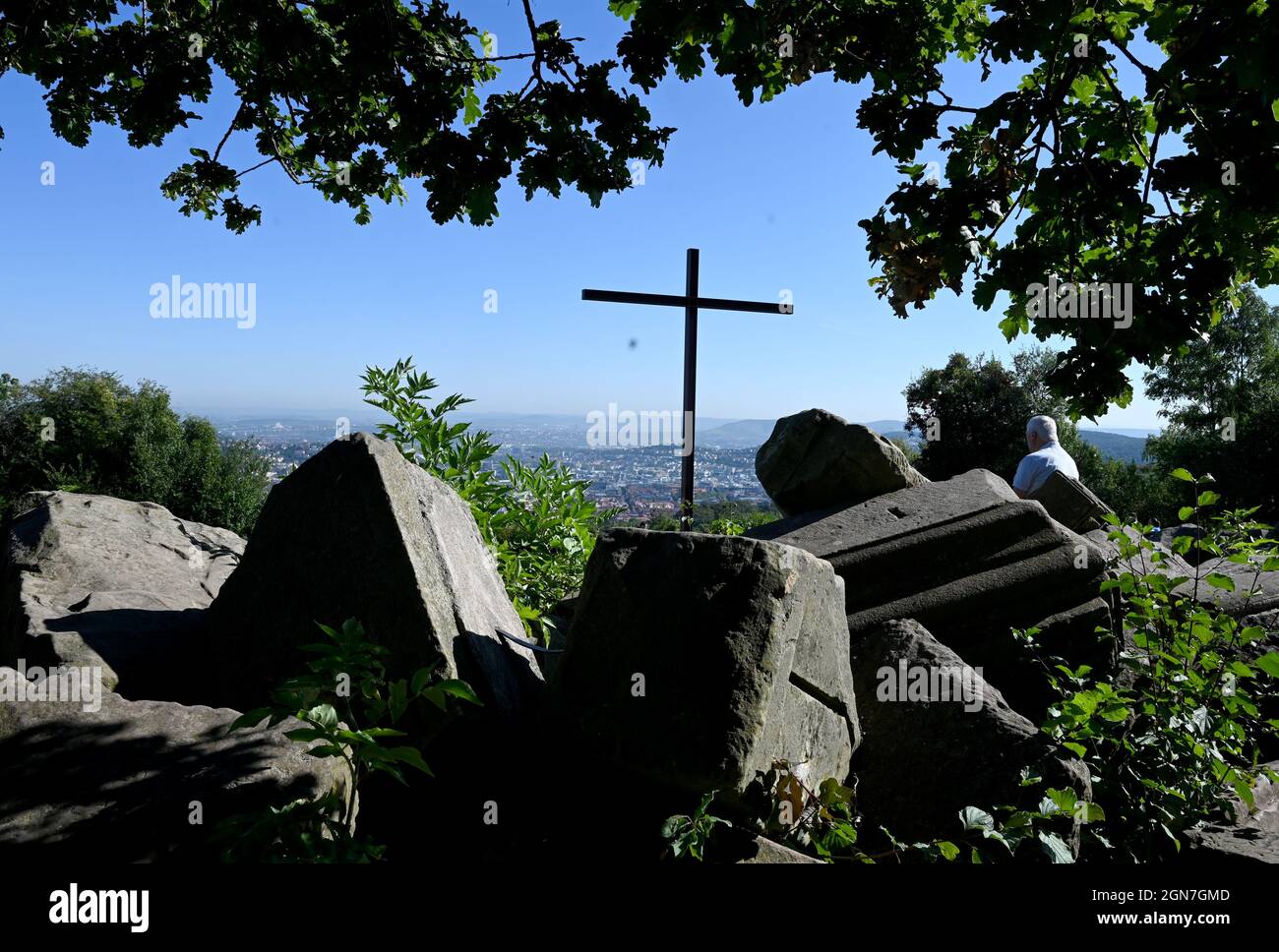 23 September 2021, Baden-Wuerttemberg, Stuttgart: A man sits in bright sunshine at the Birkenkopf viewpoint above the city of Stuttgart. The mountain was filled up with rubble after the Second World War and is therefore also called Monte Scherbelino. Photo: Bernd Weißbrod/dpa Stock Photo