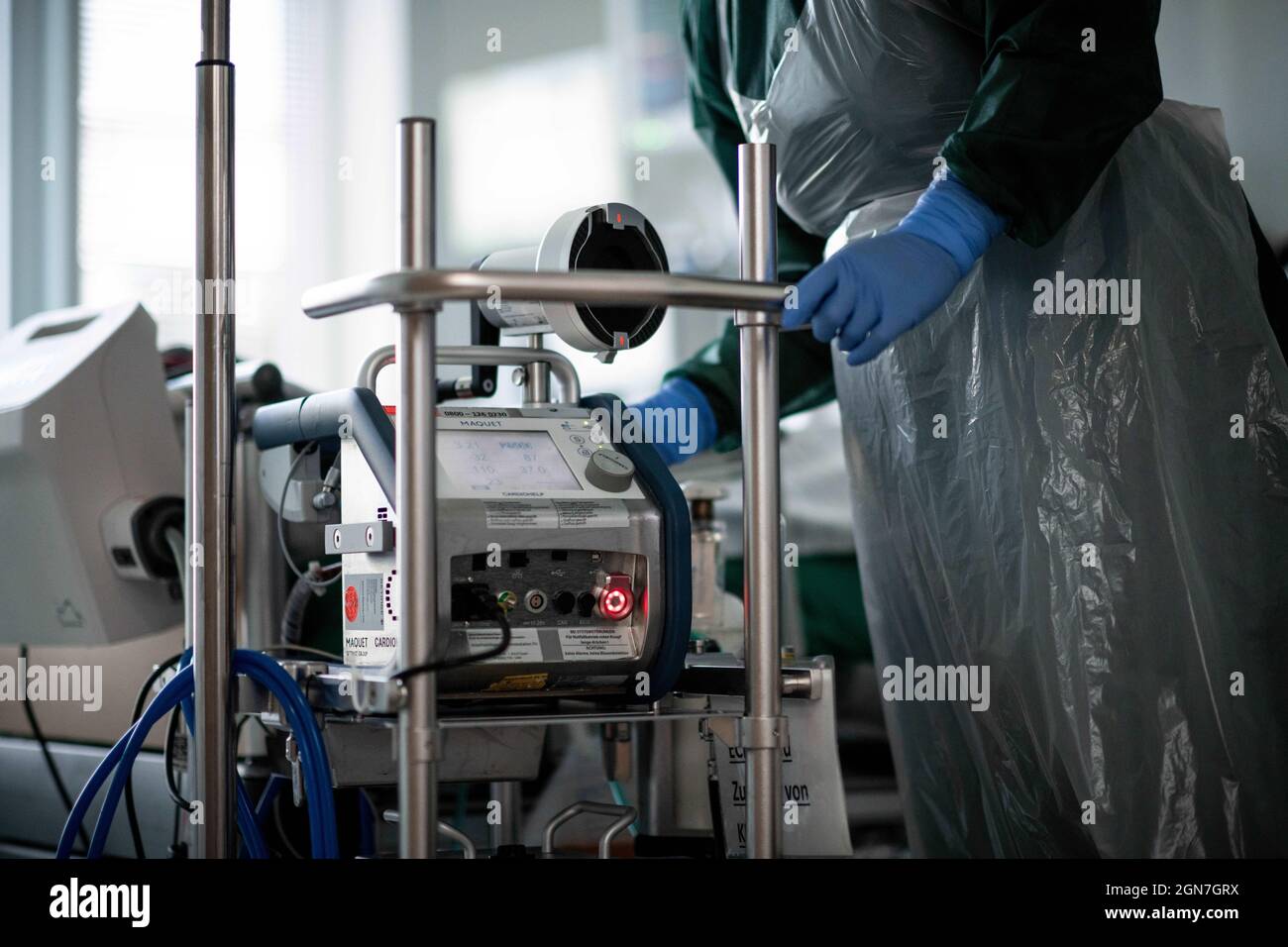 23 September 2021, North Rhine-Westphalia, Essen: A nursing staff member stands in a room of the Corona intensive care unit at Essen University Hospital and operates an ECMO device, a heart-lung machine. Patients with corona infection are treated in the IT2 intensive care unit at the Operative Center II of Essen University Hospital. Photo: Fabian Strauch/dpa Stock Photo