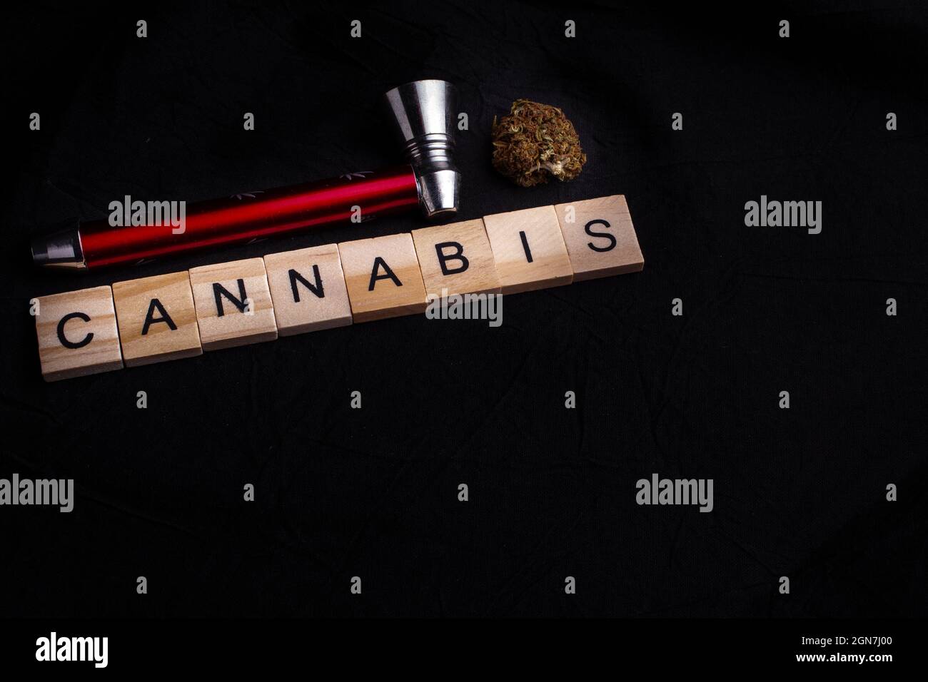 Close-Up Of Cannabis bud With Pipe, black background and cannabis text. Cannabis legalisation. Stock Photo