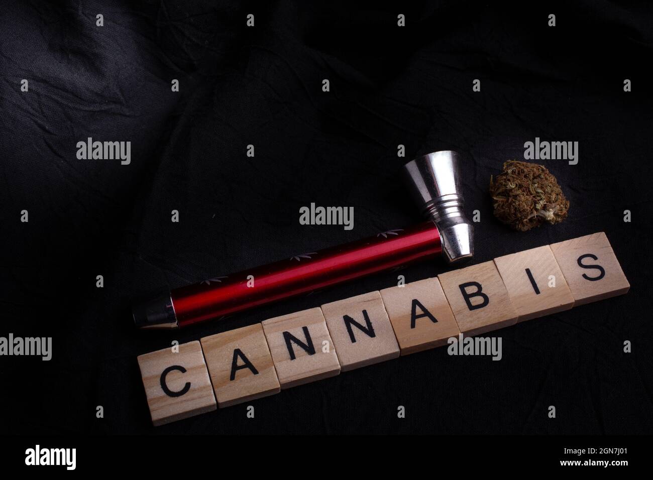 Close-Up Of Cannabis bud With Pipe, black background and cannabis text. Cannabis legalisation. Stock Photo
