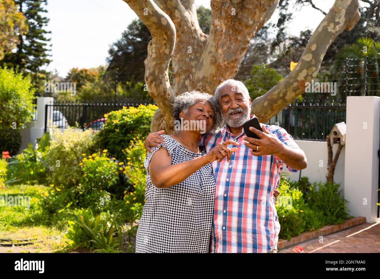 Happy african american senior couple taking selfie in garden Stock Photo