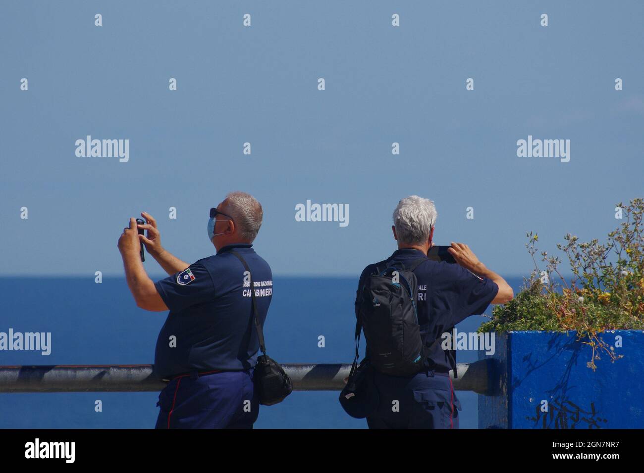 Termoli - Molise - 14 May 2021 - Two members of the National Carabinieri Association photograph the sea with their mobile phones on a warm May day Stock Photo