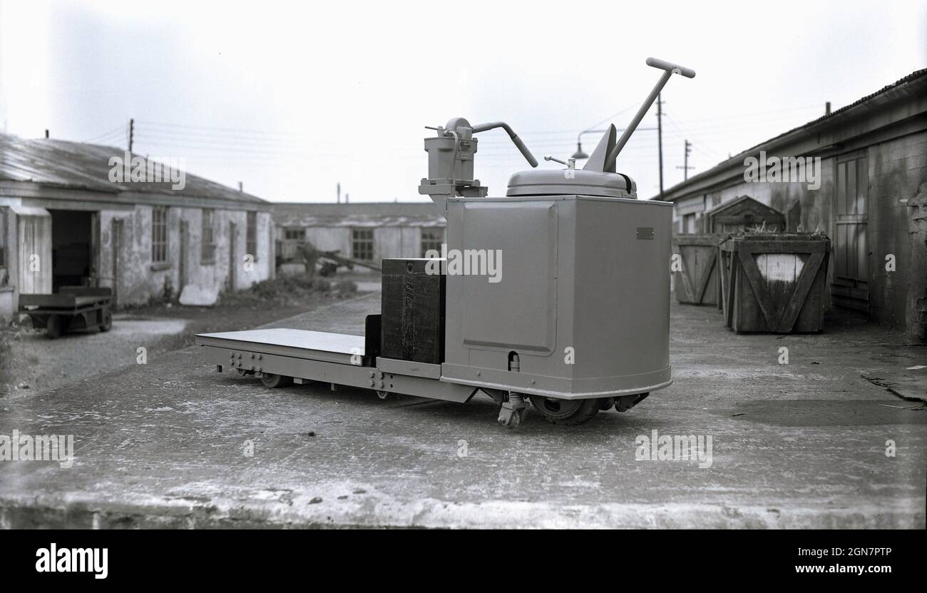 1960s, historical, a heavy duty, batter-powered electric platform trolley outside at an industrial, light-engineering site, used for moving heavy loads, England, UK. Sometimes referred to as transfer carts, as they move heavy items from one area to another. Stock Photo
