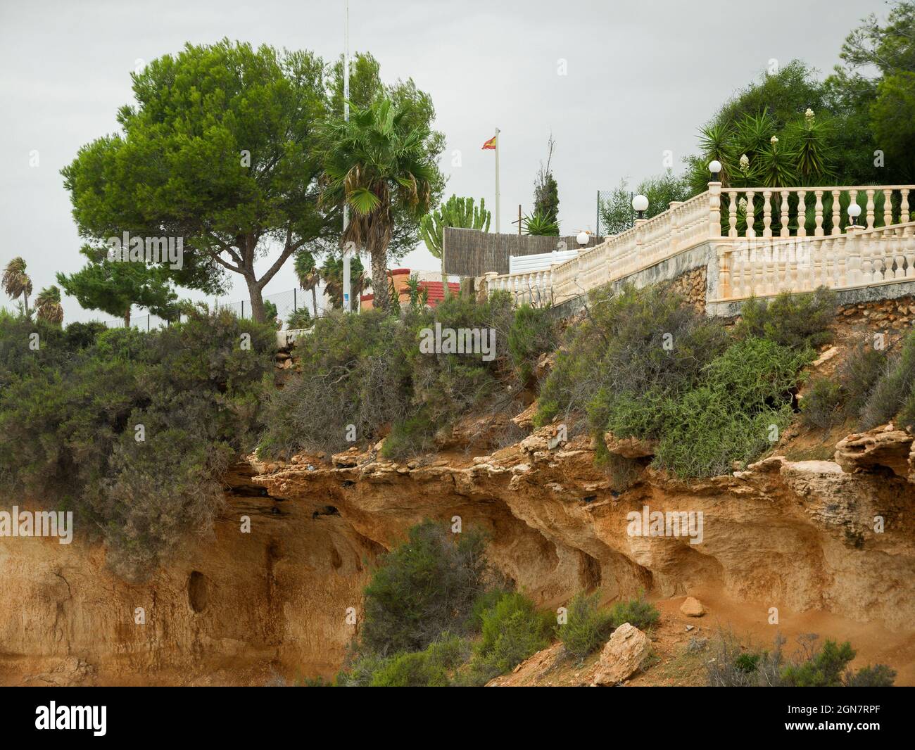 The sandstone cliffs undermined by coastal erosion at Cabo Roig, Costa Blanca, Spain, Stock Photo
