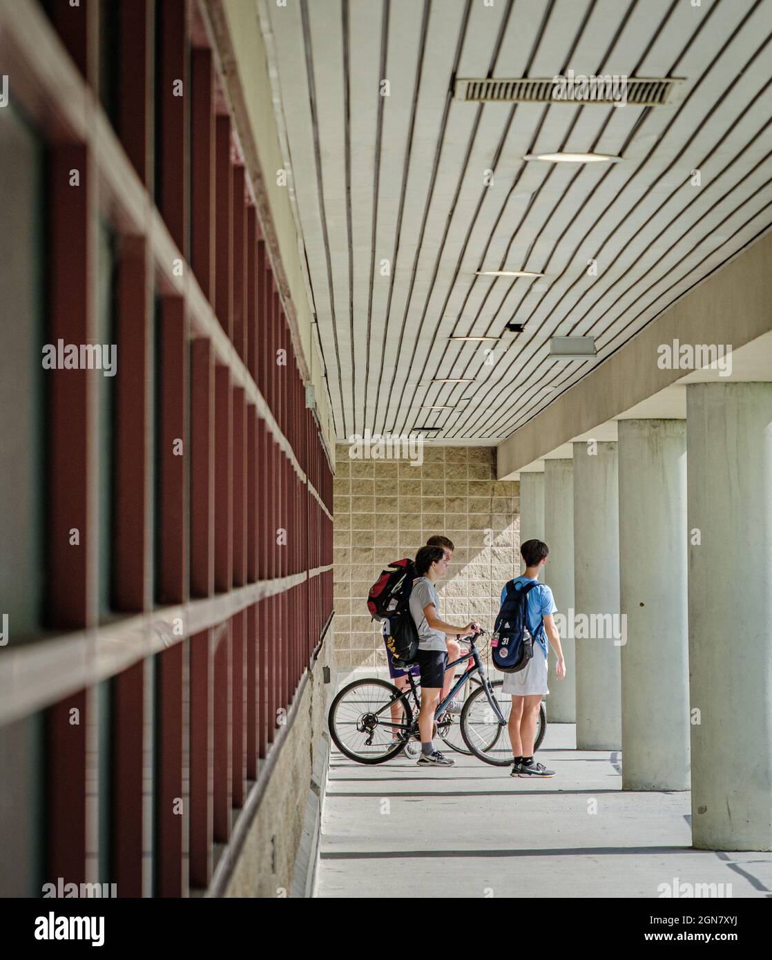 NEW ORLEANS, LA, USA - JULY 1, 2021:  Teenage boys with bikes chatting at lower level of parking garage Stock Photo