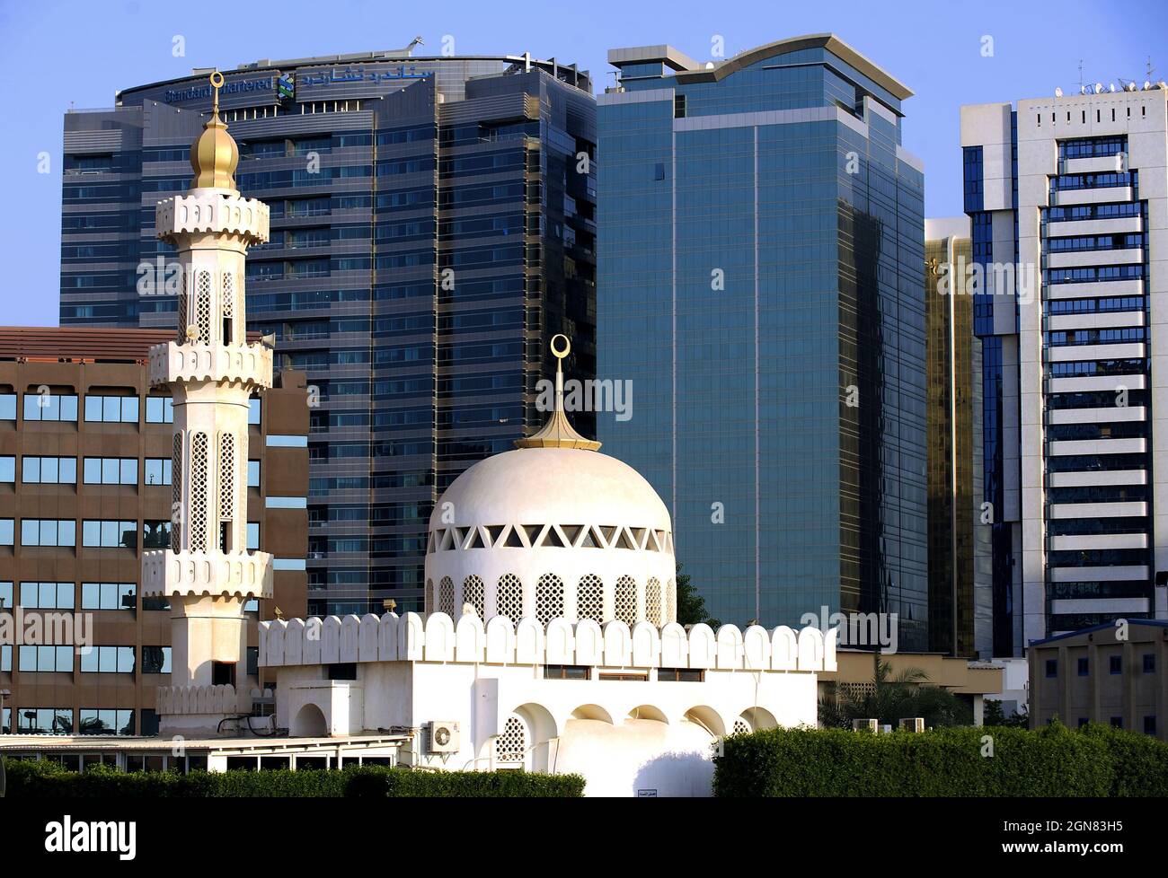 CONTRAST BETWEEN THE MODERN ARCHITECTURE OF THE SKYSCRAPERS AND THE TRADITIONAL MIDDLE EASTERN ARCHITECTURE OF A MOSQUE, ABU DHABI, CAPITAL OF THE UNI Stock Photo