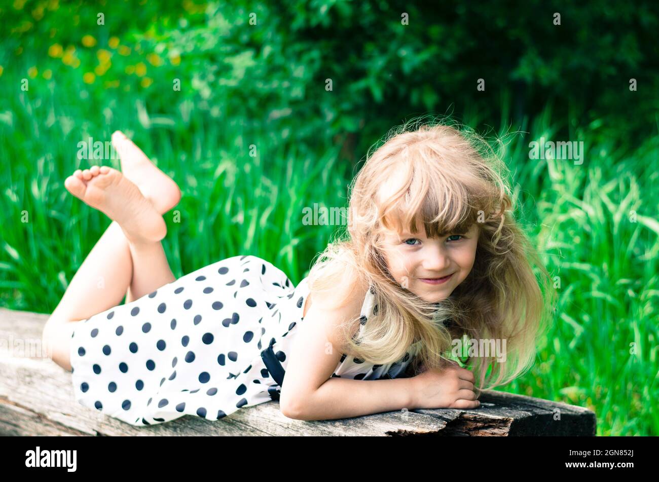 beautiful blond girl lying on bench Stock Photo