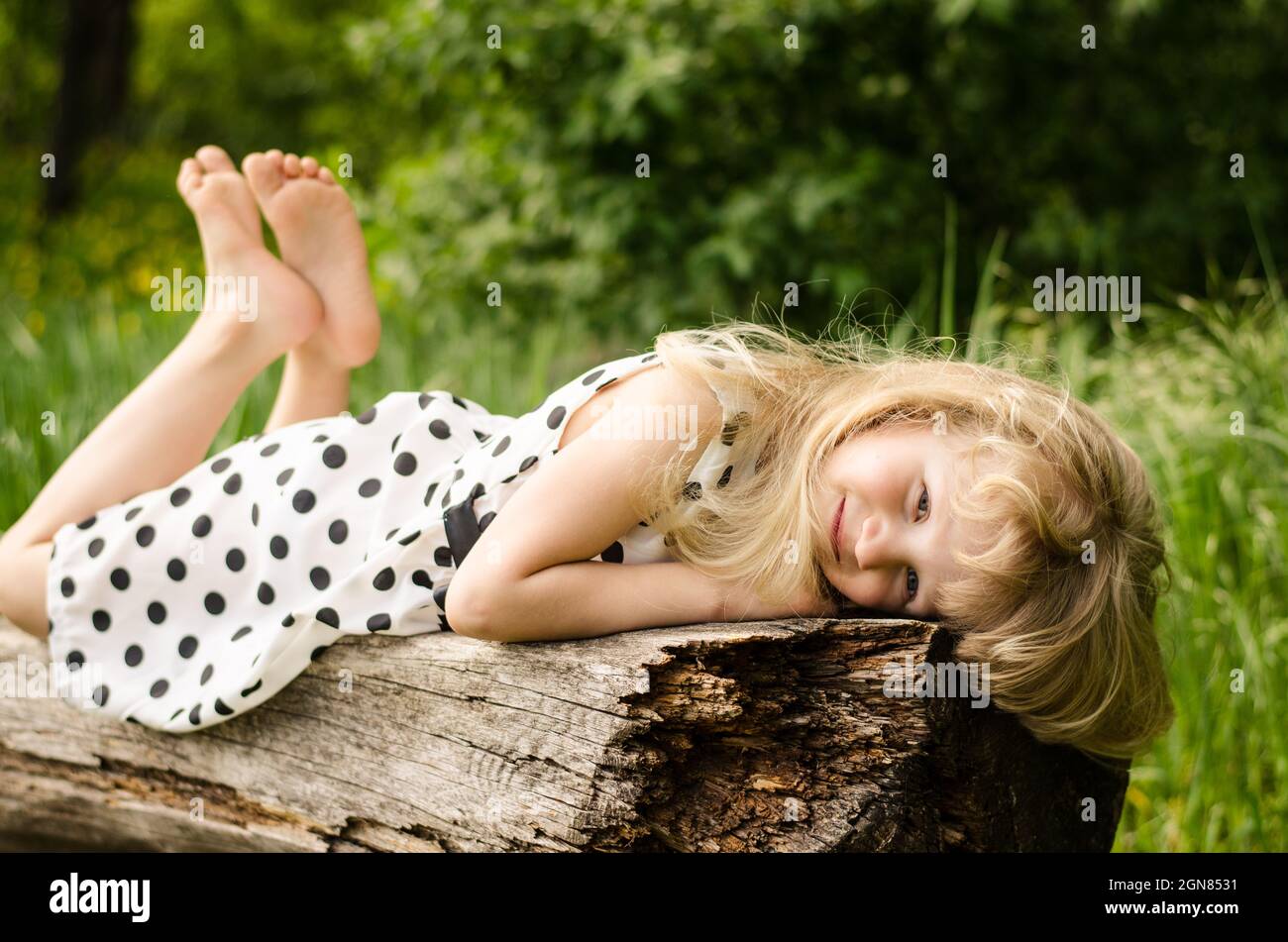 beautiful blond girl lying on bench Stock Photo