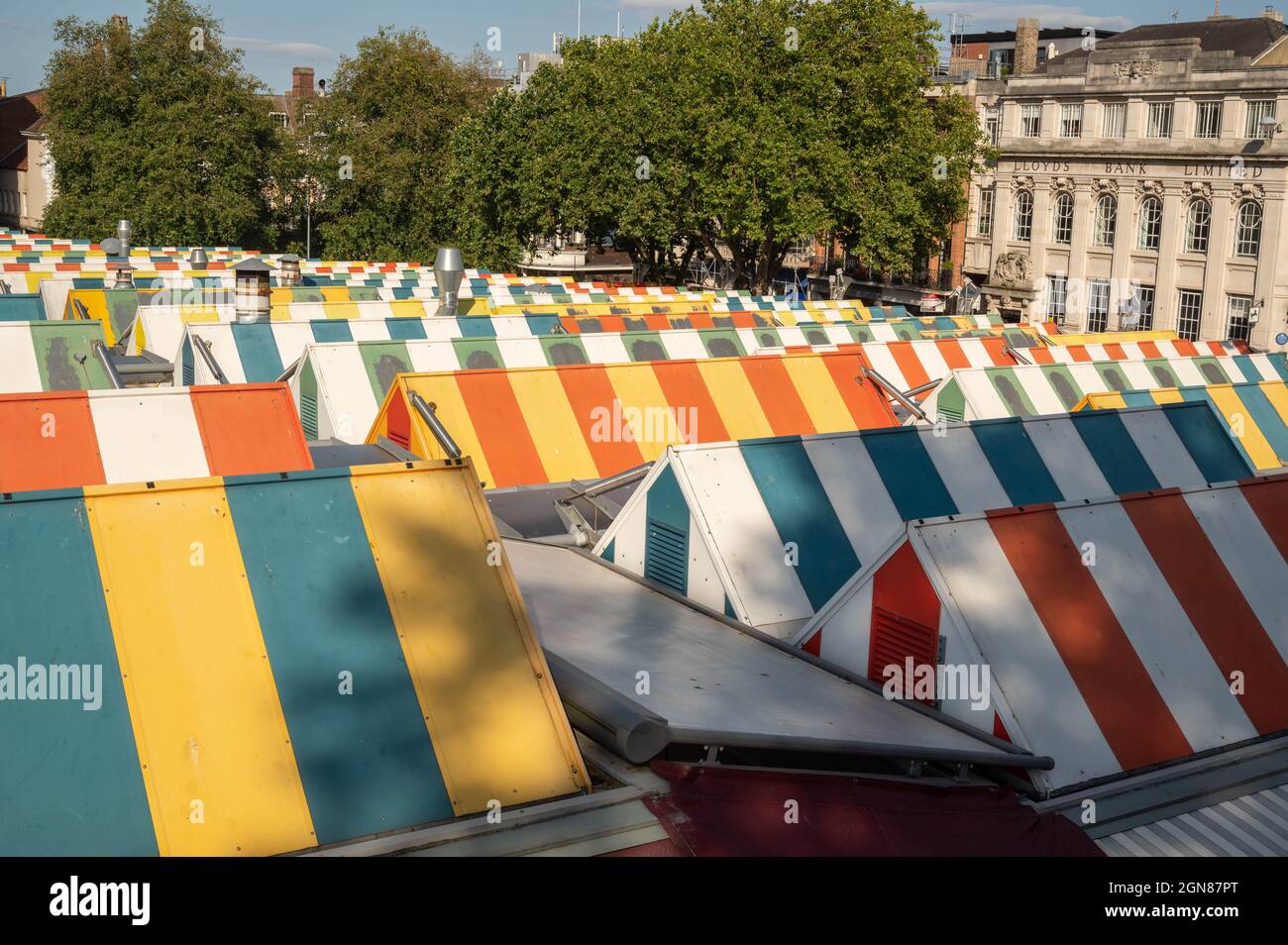 A view of the colourful striped  canopies on Norwich historic market stalls on a summers day Stock Photo