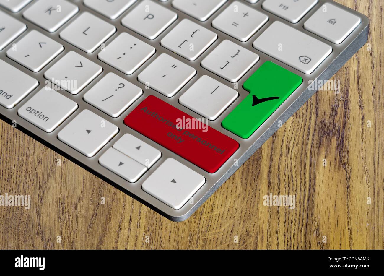 Computer keyboard shortcut keys in warning red color indicating authorised personnel  only and a green checked go button  on a natural wood backgound Stock Photo