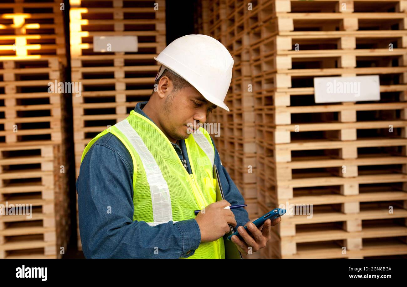 worker using smartphone in warehouse pallet Stock Photo