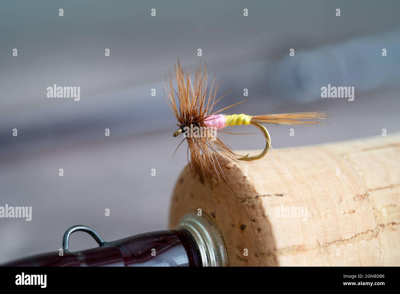 Macro of a Tups Indespensible famous English chalk stream dry fly on a cork handle of a fly rod Stock Photo