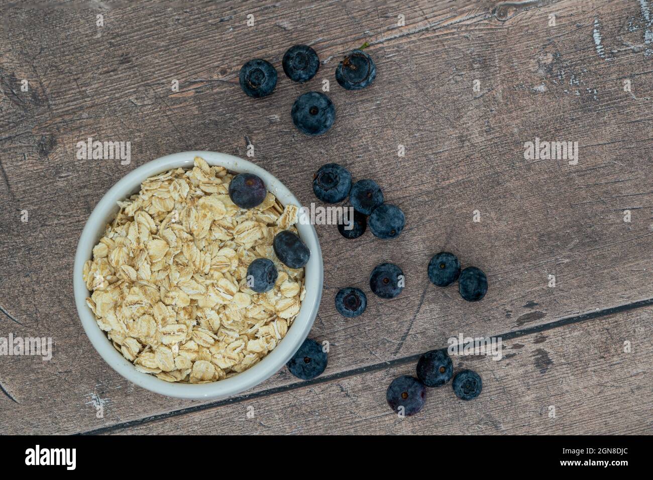 Ramekin of hot rolled oats and blueberrries on a wooden background Stock Photo