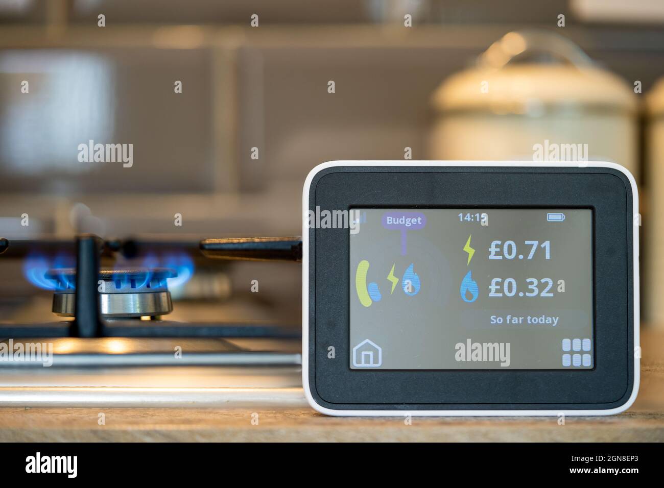 selected focus household digital smart meter against a background of a gas flame on a cooker . Stock Photo