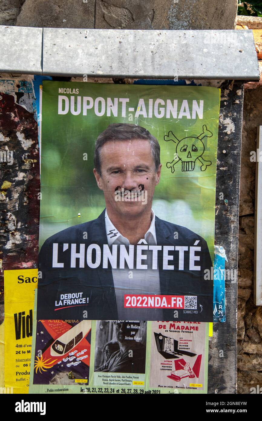 A graffitied Political poster in Beze, Cote-d'Or, Burgundy, Bourgogne-Franche-Comte, France. Stock Photo