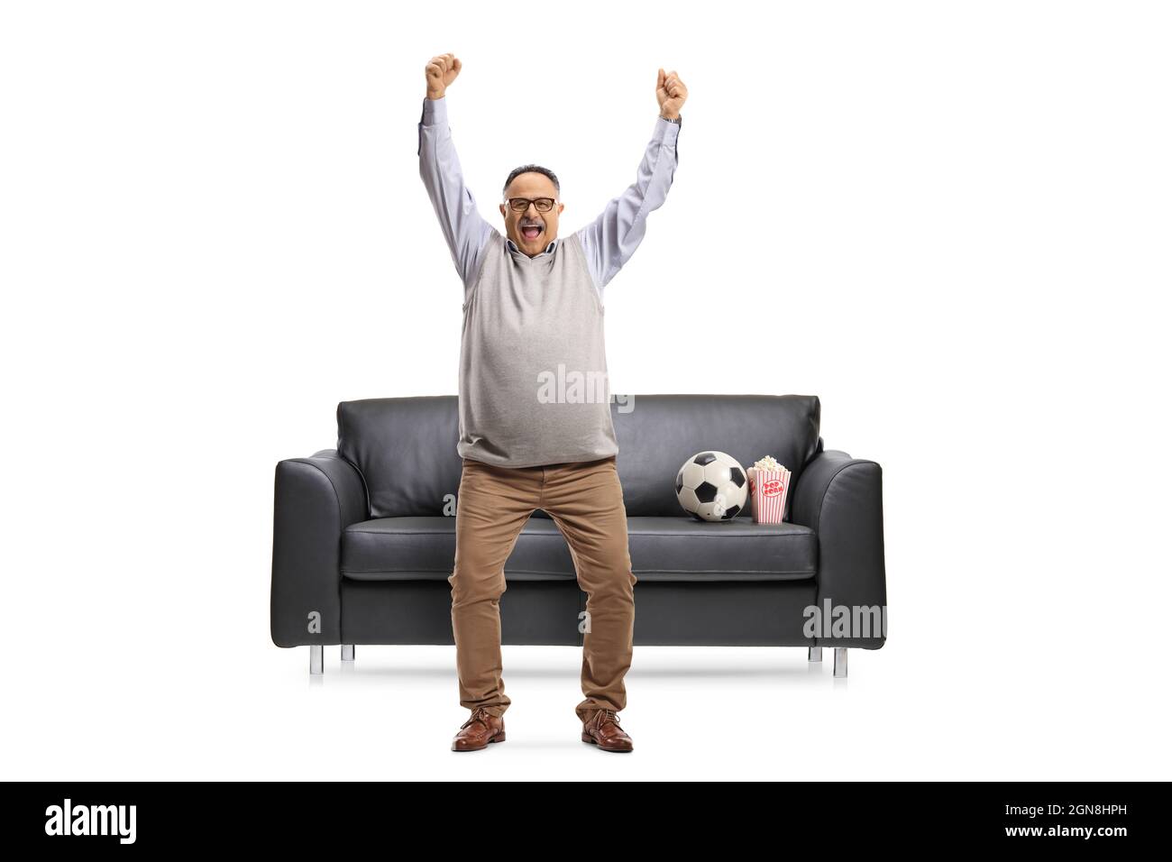 Full length portrait of a happy mature football fan cheering in front ...