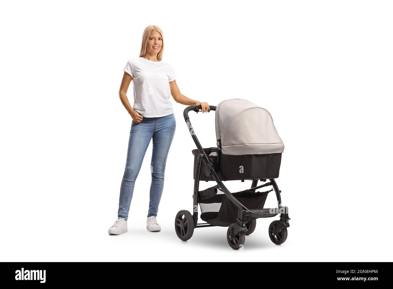 Full length portrait of a young woman in jeans with a pushchair isolated on white background Stock Photo