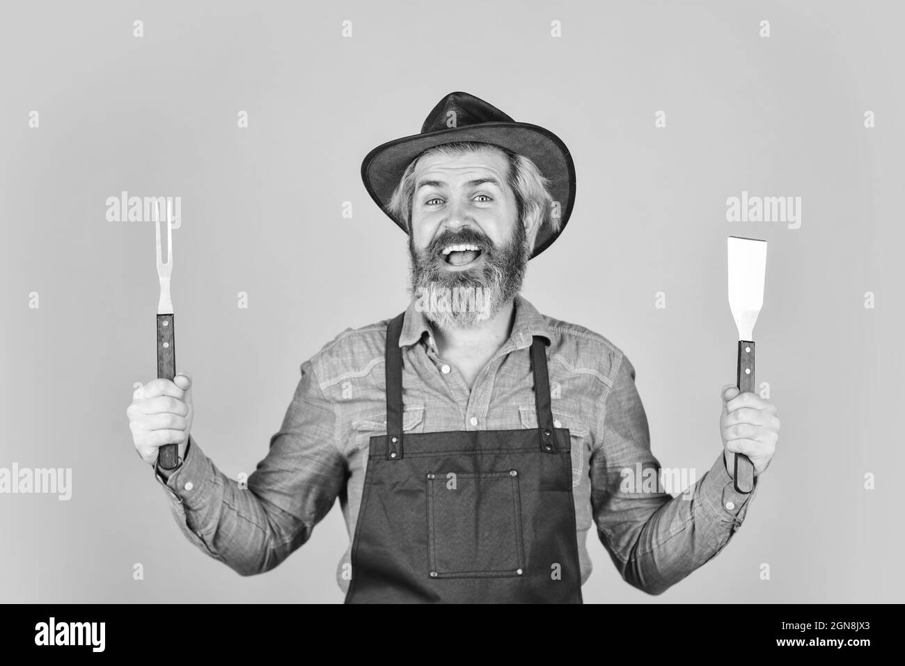 Farmer promoting bbq equipment. Cooking steak. Cooking utensils. Summer