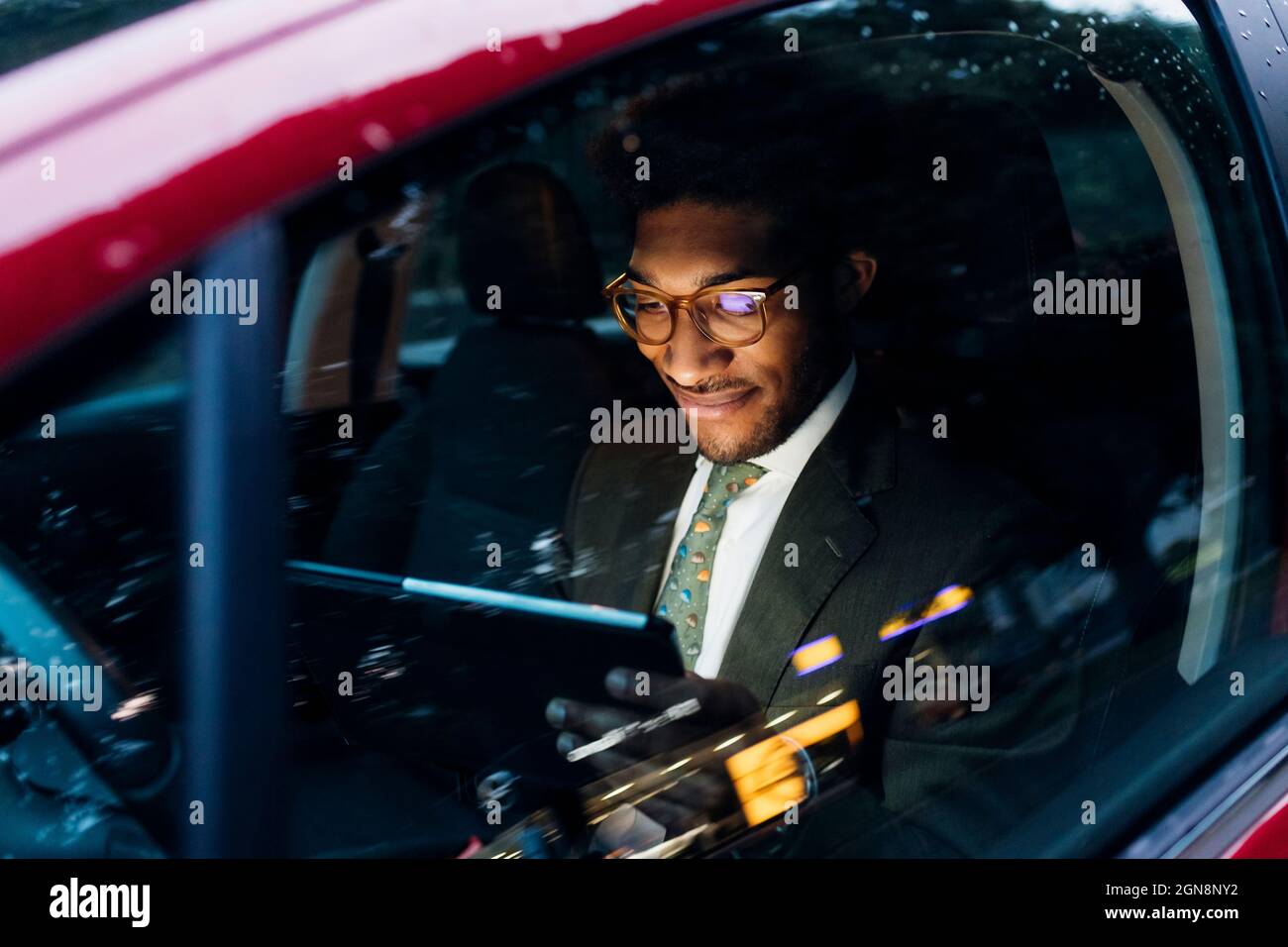 Smiling businessman using digital tablet while sitting in car Stock Photo