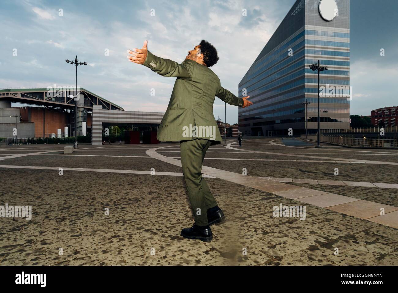 Businessman with arms outstretched spinning on footpath Stock Photo