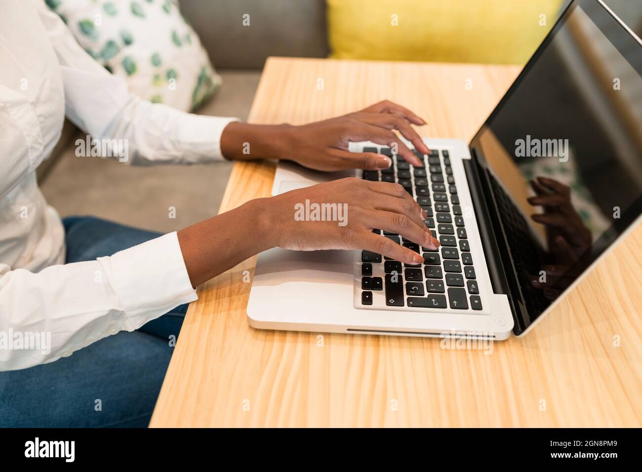 Female freelancer using laptop at table in cafe Stock Photo