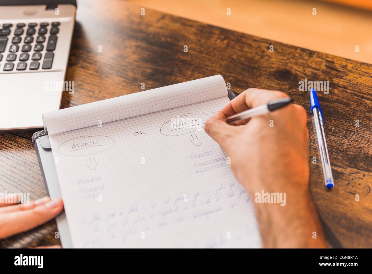 Male mental health expert writing in note pad at office Stock Photo