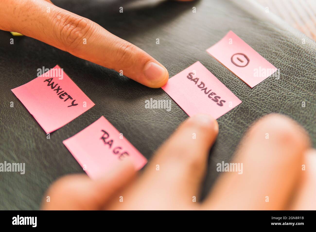 Male doctor with pink adhesive notes on leather at office Stock Photo