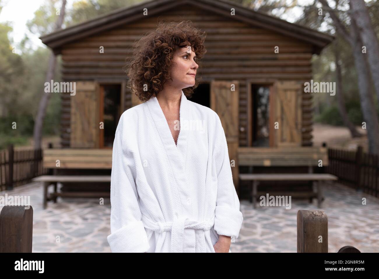 Woman wearing bathrobe standing in front of cabana Stock Photo