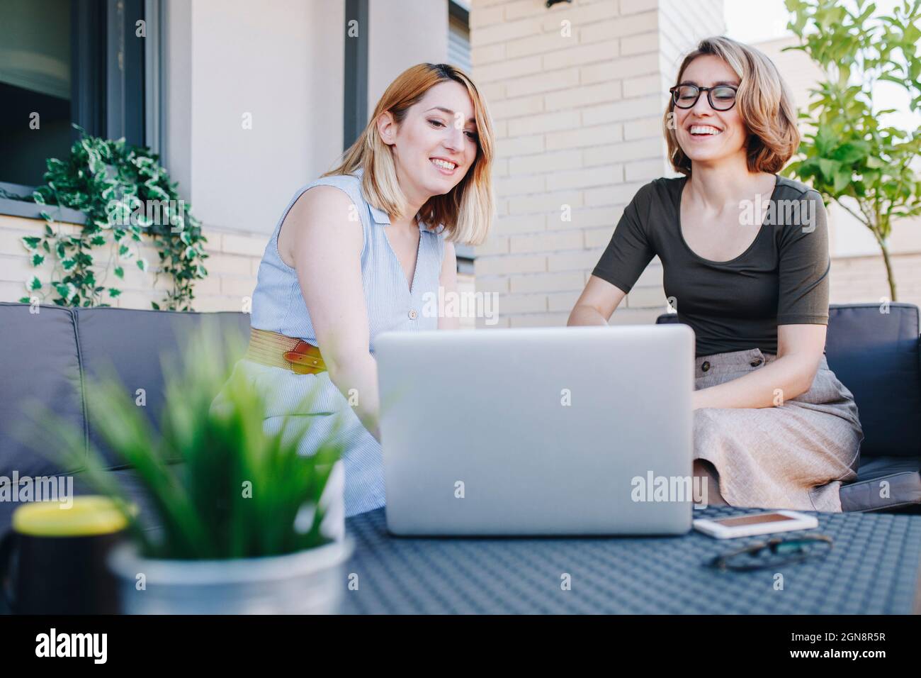 Businesswomen using laptop while sitting on sofa Stock Photo