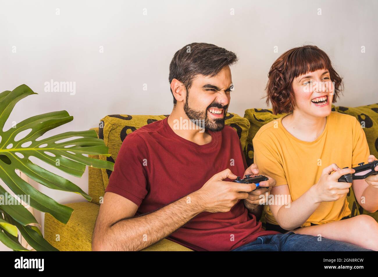 Man disappointed while playing video game with girlfriend at home stock  photo