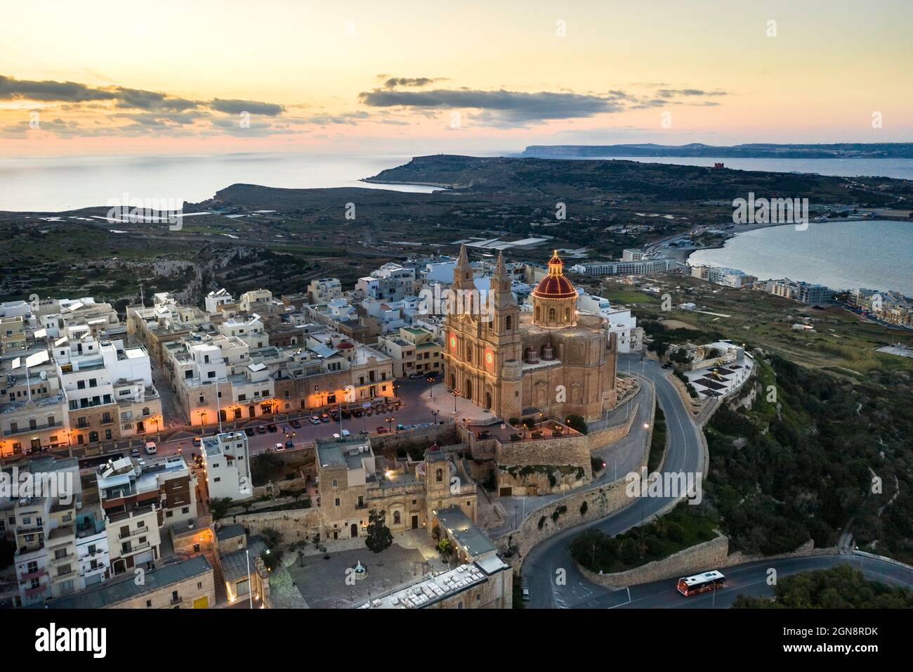 Malta, Northern Region, Mellieha, Aerial view of coastal town at dusk with Parish Church of Nativity of Virgin Mary in center Stock Photo