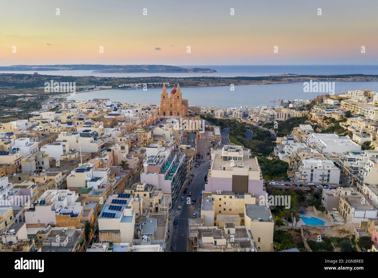 Malta, Northern Region, Mellieha, Aerial view of coastal town at dusk with Parish Church of Nativity of Virgin Mary in background Stock Photo