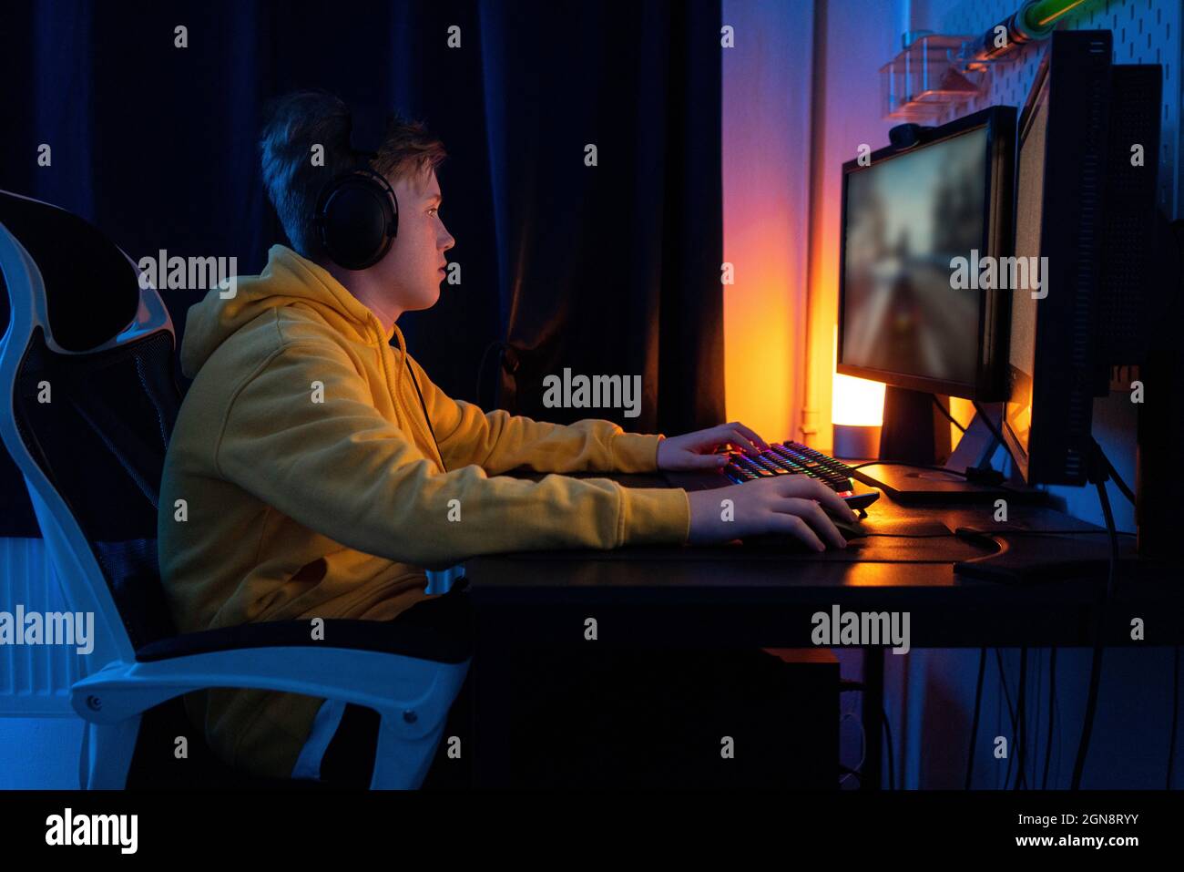 Boy playing game on desktop PC on table at home Stock Photo