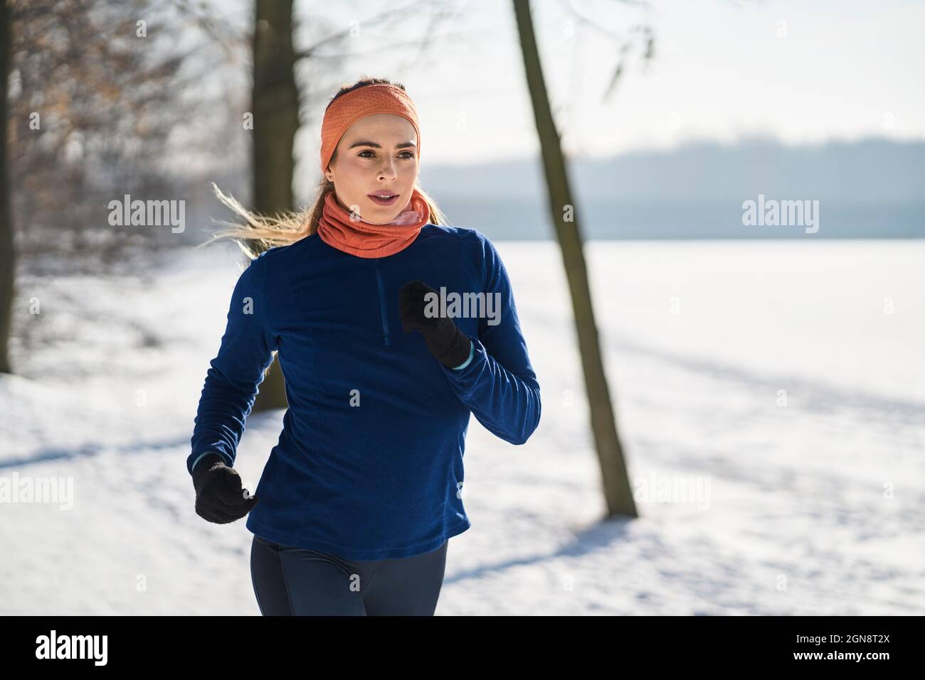 Young woman in sports clothing jogging during winter Stock Photo