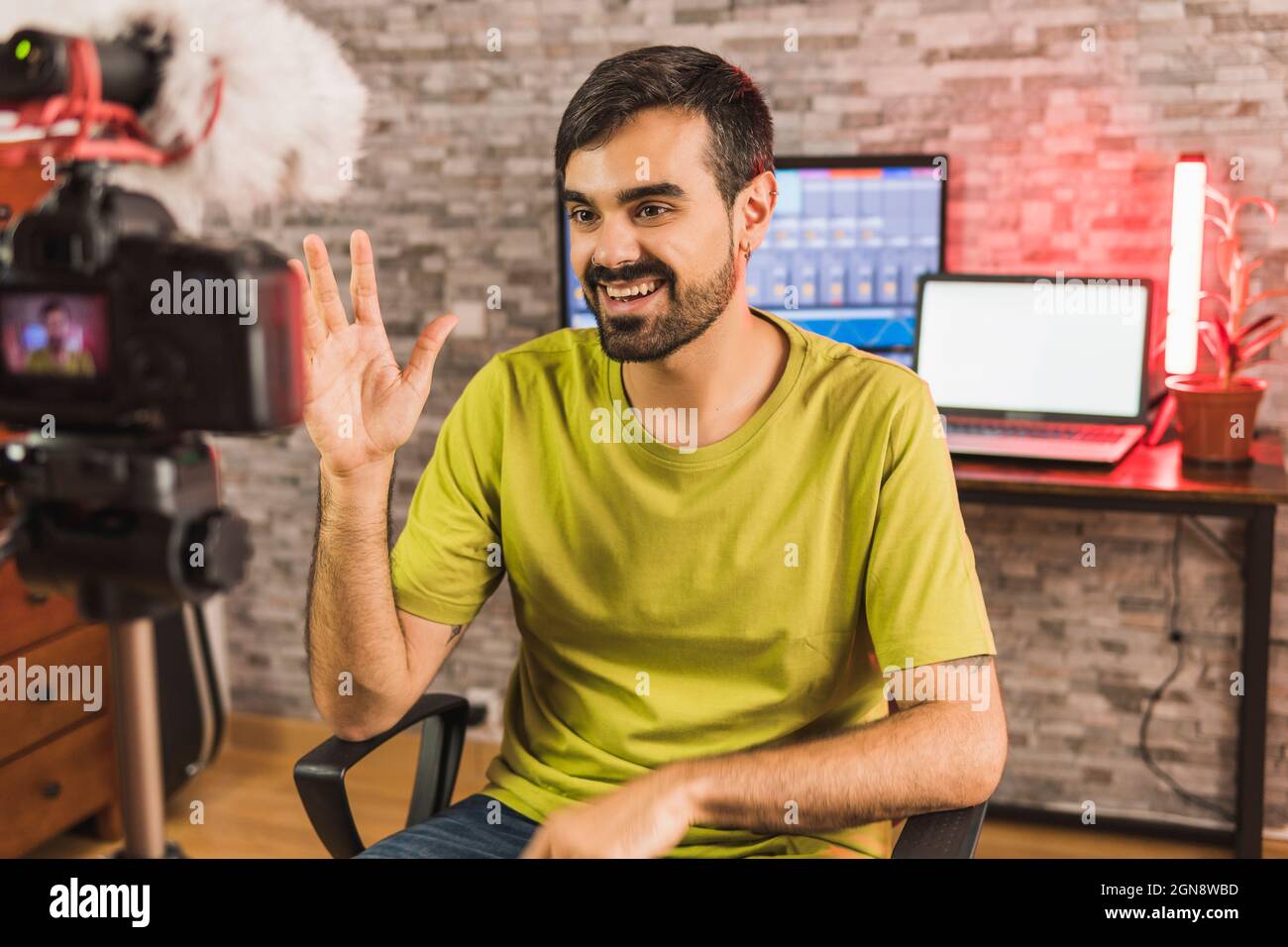 Smiling young male influencer filming in home video camera Stock Photo