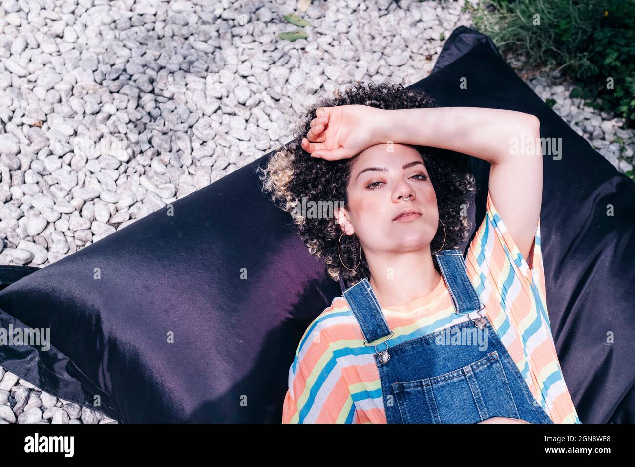 Woman relaxing on bean bag at backyard Stock Photo - Alamy