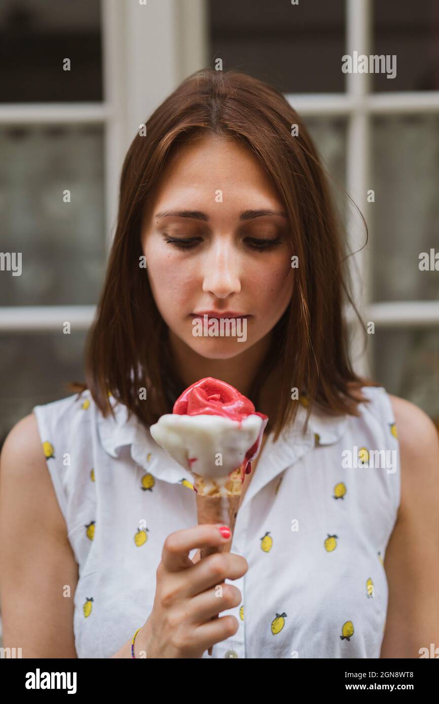 Young woman with brown hair looking at ice cream Stock Photo Alamy