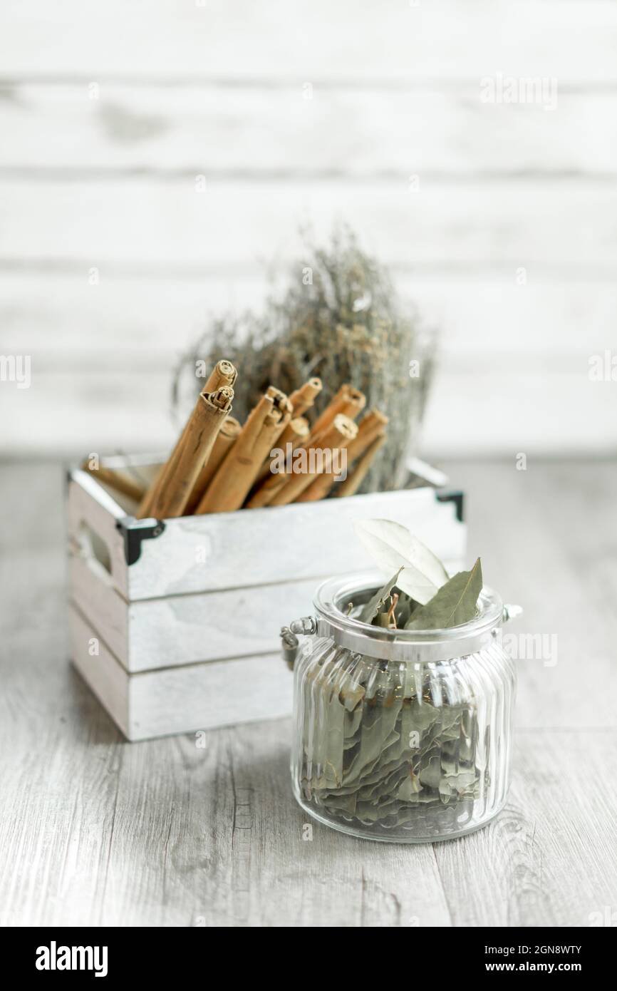 Arrangement of bay leafs in jar with cinnamon sticks and rosemary in container Stock Photo