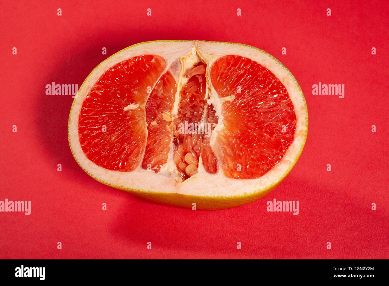 sliced yellow grapefruit on red background Stock Photo