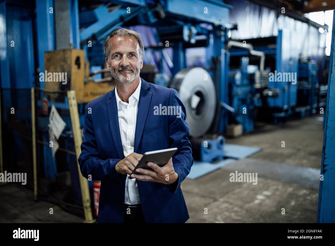 Senior male inspector with digital tablet at steel mill Stock Photo