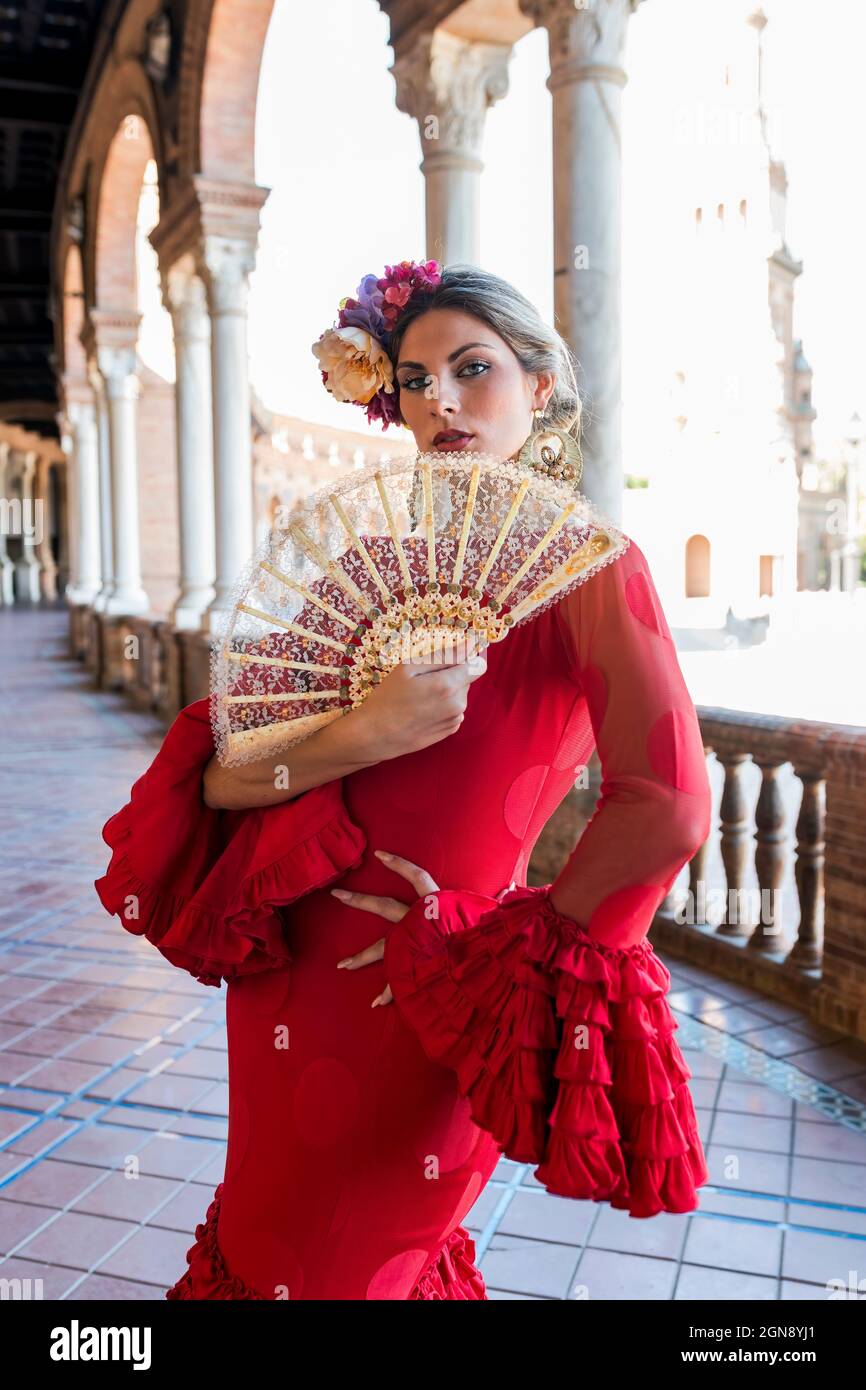 Female flamenco artist holding hand fan while standing at Plaza De Espana, Seville, Spain Stock Photo