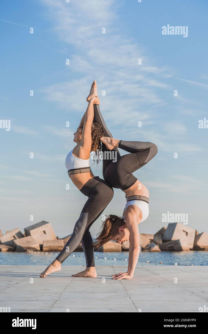 Young women practicing acroyoga on boardwalk Stock Photo