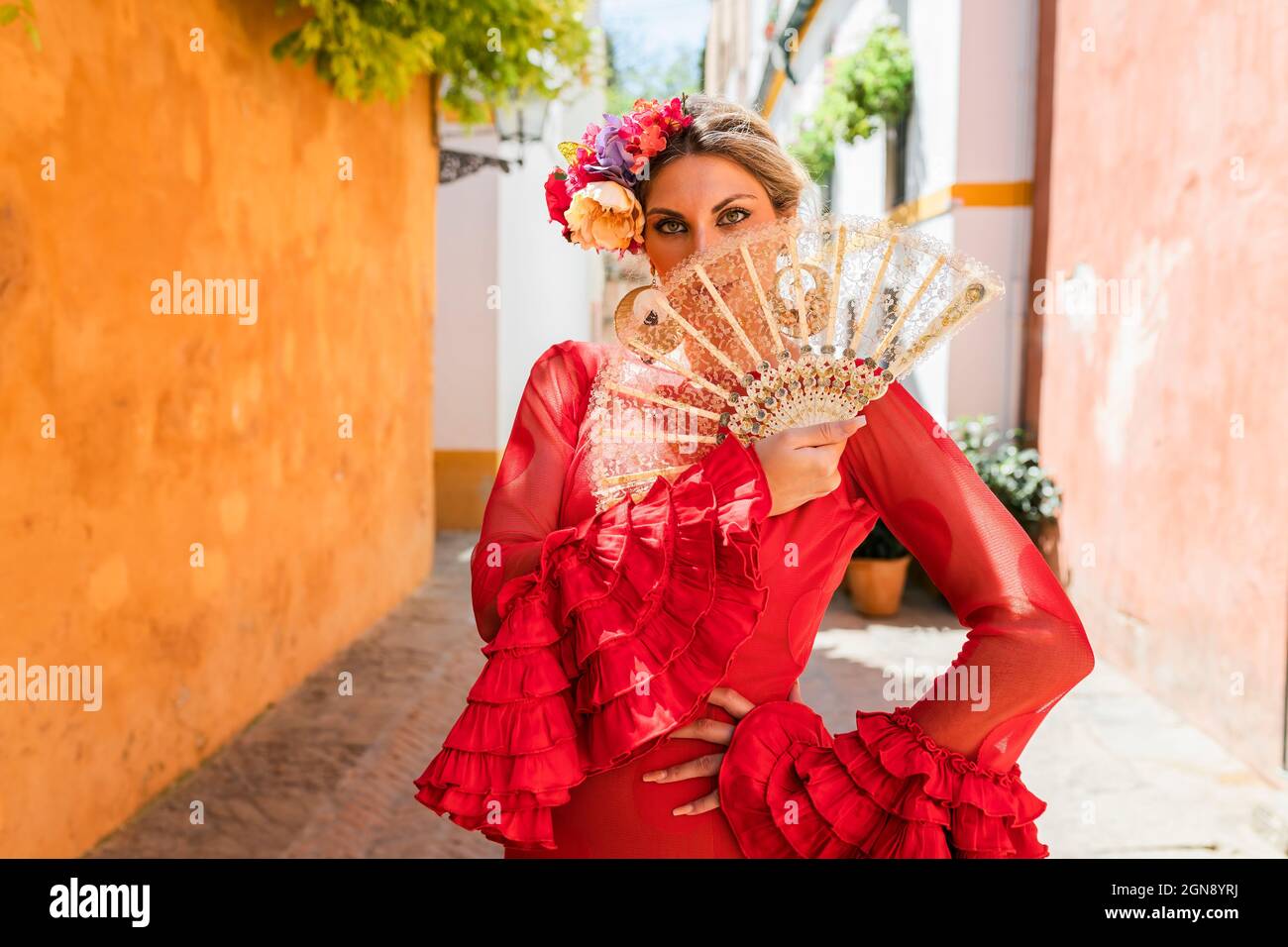 Female flamenco artist standing with hand on hip at alley Stock Photo