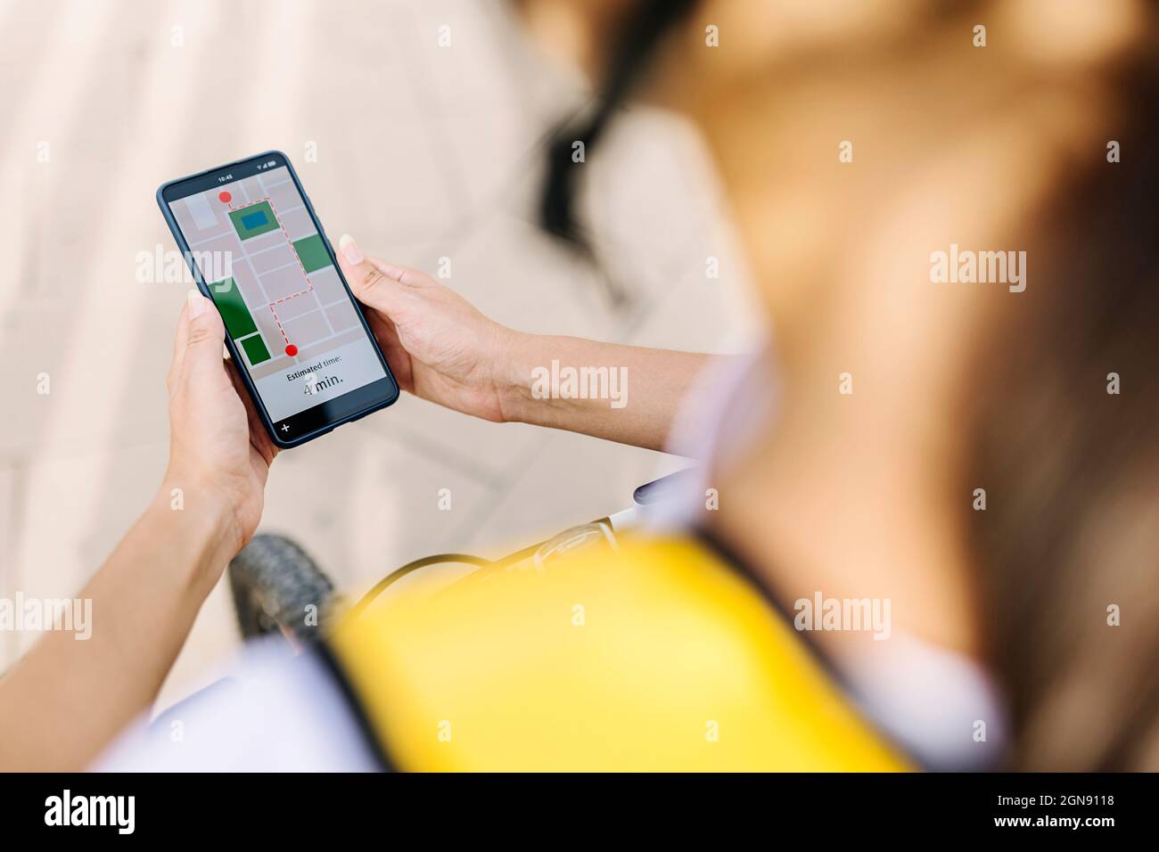 Female delivery person checking direction through smart phone Stock Photo